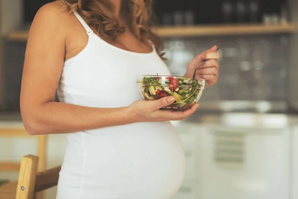 Беременная женщина ест здоровый салат — стоковое фото