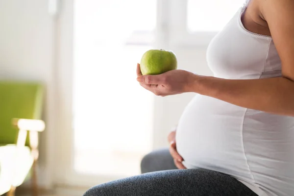 Mulher grávida comendo maçã — Fotografia de Stock