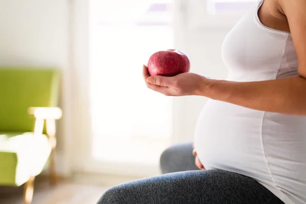 Gravid kvinna äter äpple — Stockfoto