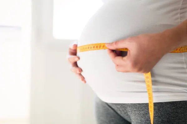 Mulher grávida medindo barriga — Fotografia de Stock