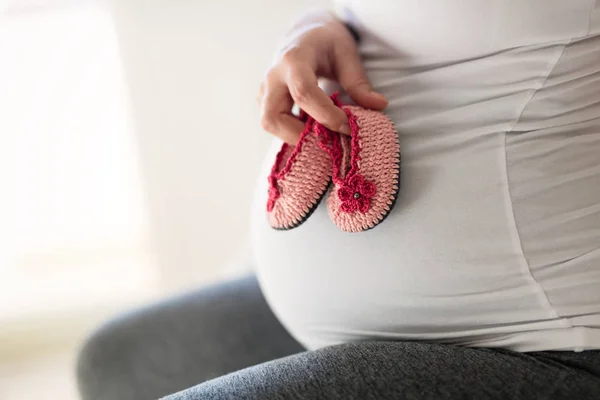 Έγκυος γυναίκα εκμετάλλευση νεογέννητο παπούτσια — Φωτογραφία Αρχείου