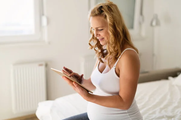 Femme enceinte relaxante et utilisant un comprimé — Photo