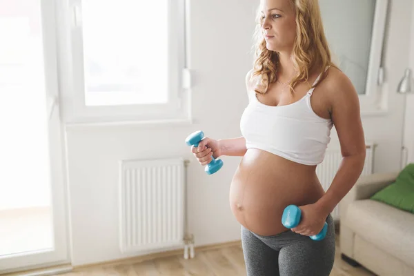 Mulher grávida treinando com halteres — Fotografia de Stock