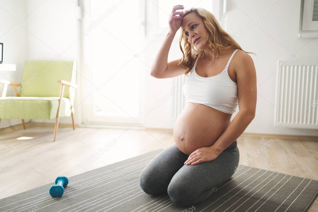Tired exercising pregnant woman