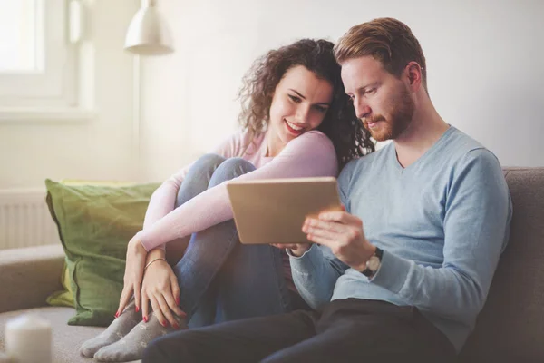 Casal feliz surfando em tablet em casa — Fotografia de Stock