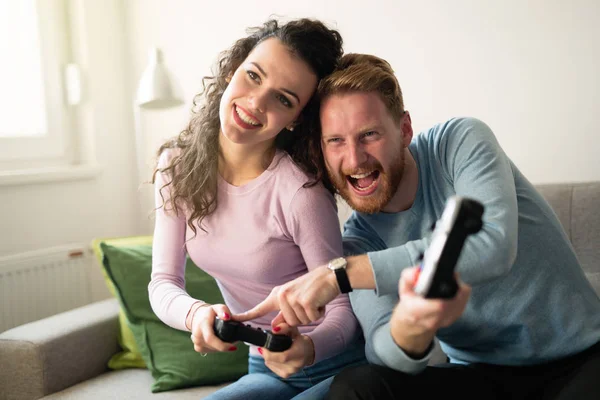 Красивая пара, играющая в видеоигры на консоли — стоковое фото