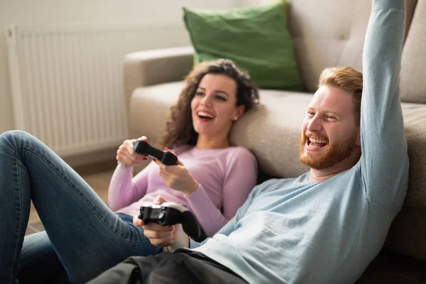 Beautiful couple playing video games on console — Stock Photo, Image