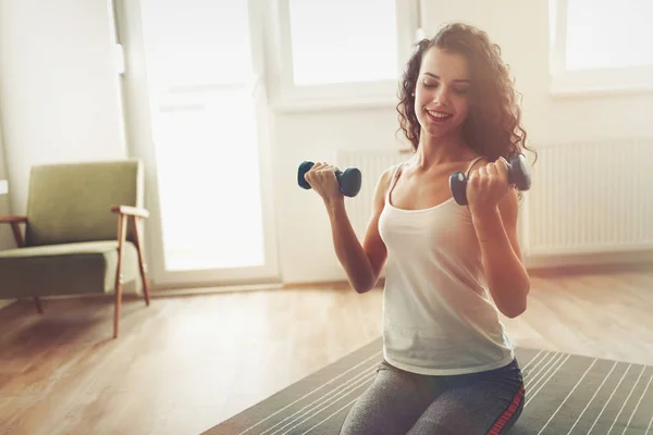 Sportliche Frau trainiert zu Hause, um fit zu bleiben — Stockfoto