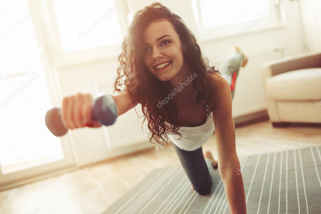 Fit  sportswoman exercising at home