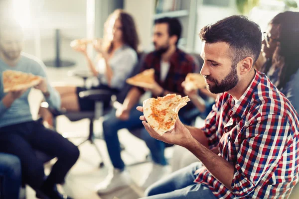 Compañeros comiendo pizza durante el descanso en la oficina — Foto de Stock