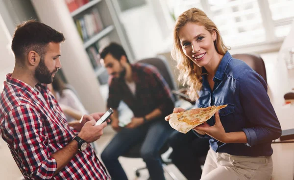 Коллеги едят пиццу во время перерыва на работе — стоковое фото