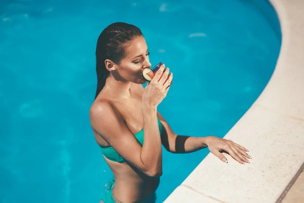 Женщина наслаждается коктейлем в бассейне — стоковое фото