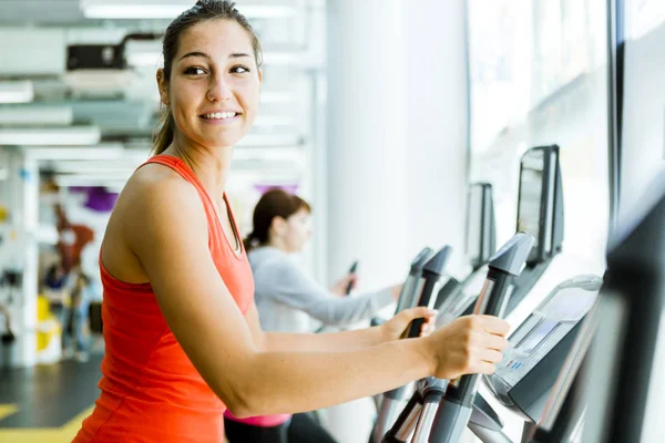 Mujer usando elíptica entrenador — Foto de Stock