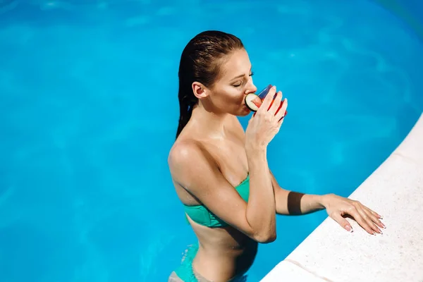 Mulher desfrutando de coquetel na piscina — Fotografia de Stock