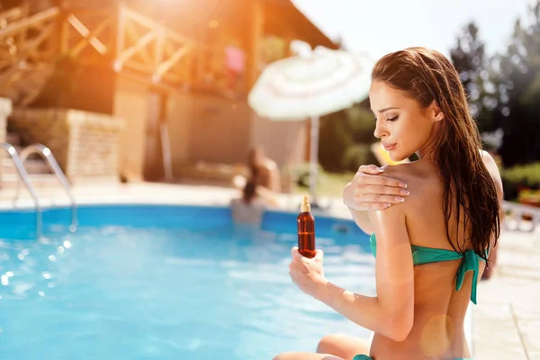 Mujer aplicando loción solar — Foto de Stock