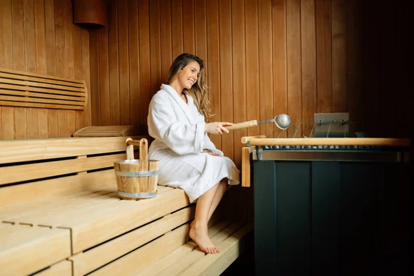 Sıcak taşlar yağlar dökme saunada güzel kadın