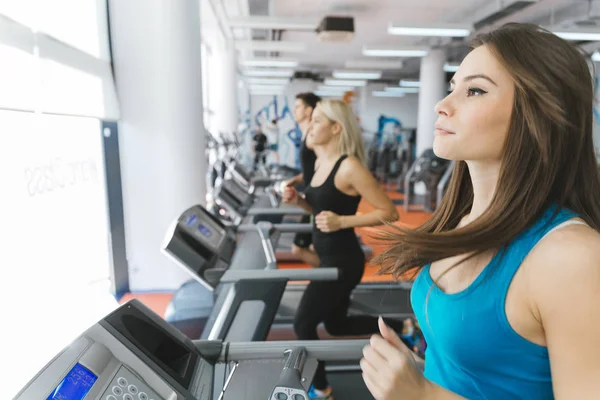 Les gens sur les tapis roulants dans la salle de gym — Photo