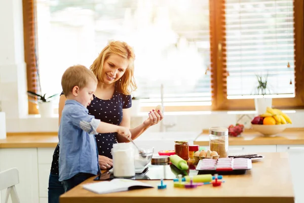 Kind hilft Mutter beim Plätzchenbacken — Stockfoto