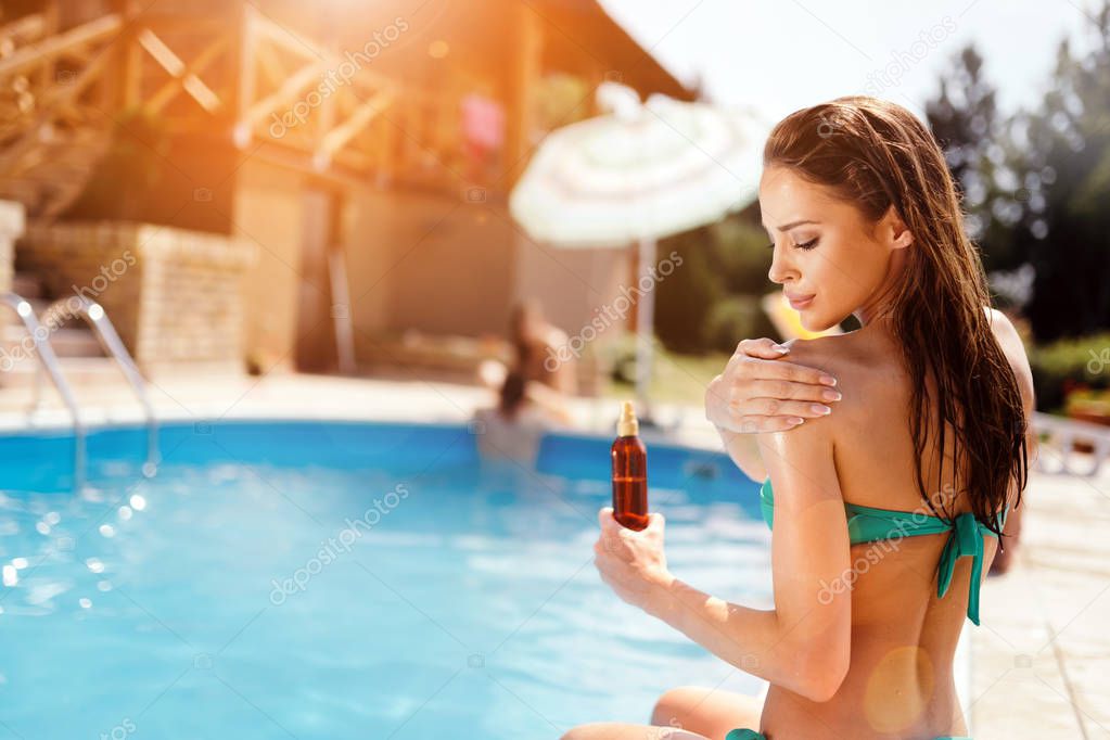 Woman applying sun lotion