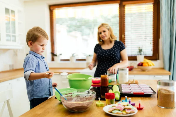 Ребенок помогает матери на кухне — стоковое фото