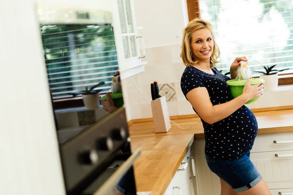 Gravid kvinna som arbetar i köket — Stockfoto