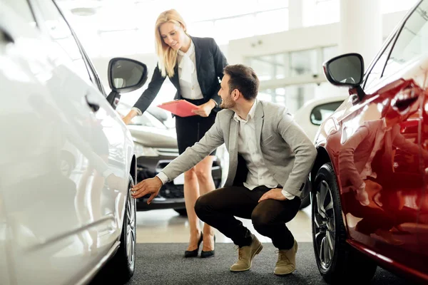 Car salesperson explaining tires options — Stock Photo, Image