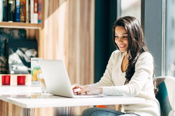 Brunetka korzysta z laptopa w kawiarni — Zdjęcie stockowe