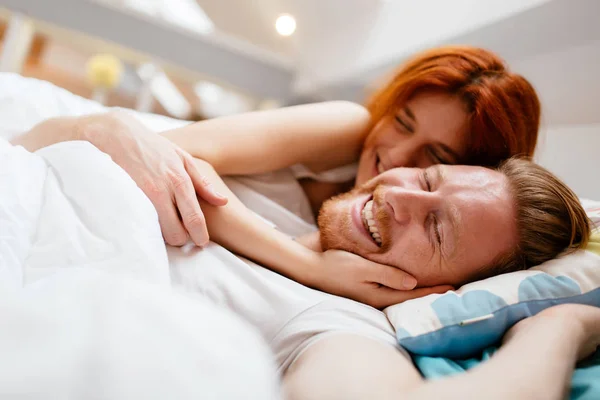 Schönes Paar lächelt im Bett — Stockfoto