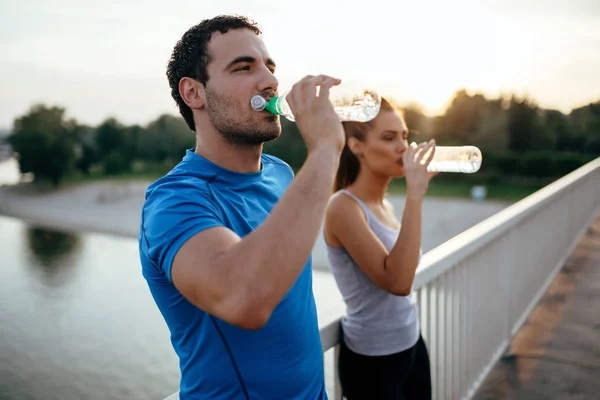 Sportliches Paar trinkt Wasser — Stockfoto
