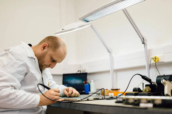 Technicus fixing moederbord door solderen — Stockfoto