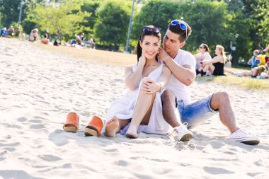 Bir kumsalda oturup romantik genç Çift