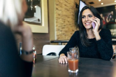 Güzel esmer Cafe telefonda konuşuyor