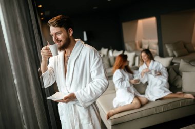 Yakışıklı erkek bornoz çay içme '