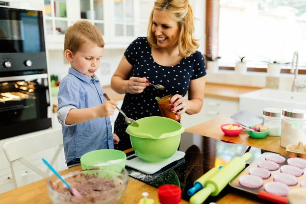 Niño ayudando a la madre hornear galletas —  Fotos de Stock