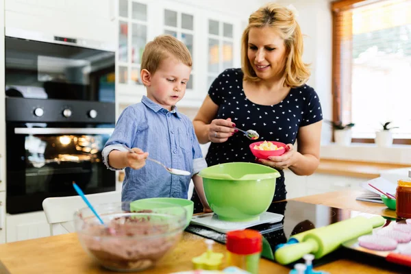 Niño lindo inteligente ayudando a la madre en la cocina —  Fotos de Stock