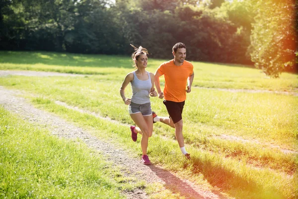 Healthy fit couple running in nature — Stock Photo, Image