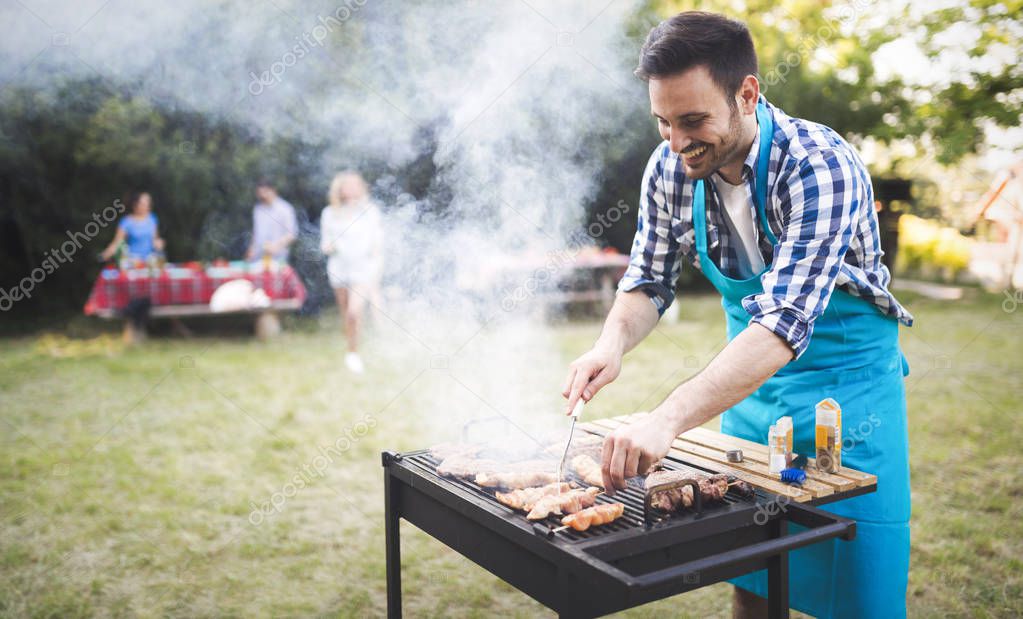 Handsome male preparing barbecue