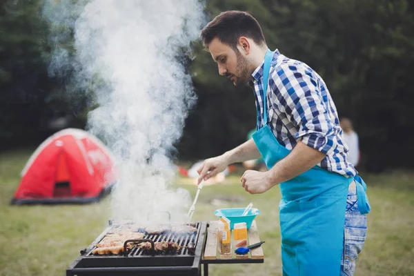 Handsome male grilling meat — Stock Photo, Image