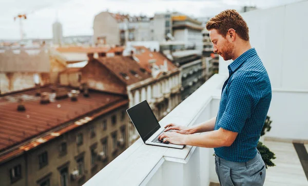 Pessoa usando laptop no telhado — Fotografia de Stock