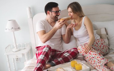 Çift yatakta kahvaltı yiyor 