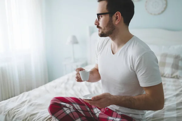 Homem de pijama desfrutando de café — Fotografia de Stock