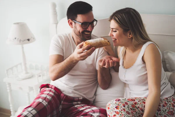 Casal come café da manhã na cama — Fotografia de Stock