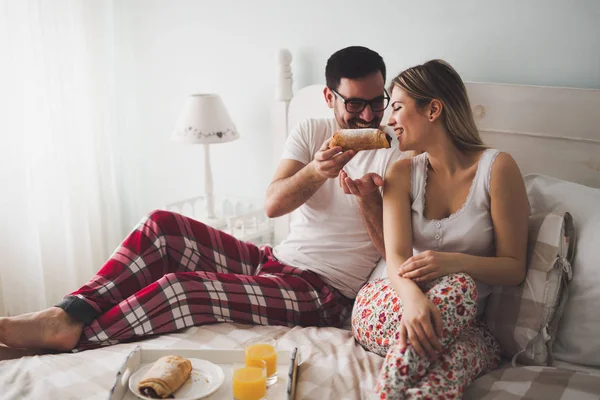 Casal come café da manhã na cama — Fotografia de Stock