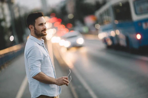 Handsome man walking along night road — Stock Photo, Image