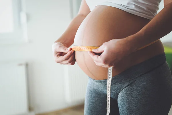 Zwangere vrouw haar buik meten — Stockfoto