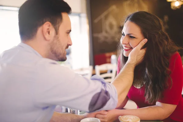 Пара флиртует и улыбается в кафе — стоковое фото