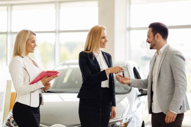 Araba anahtarını vererek saleswomen