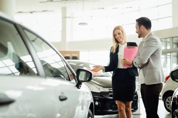 Mujer vendiendo coches en el concesionario — Foto de Stock