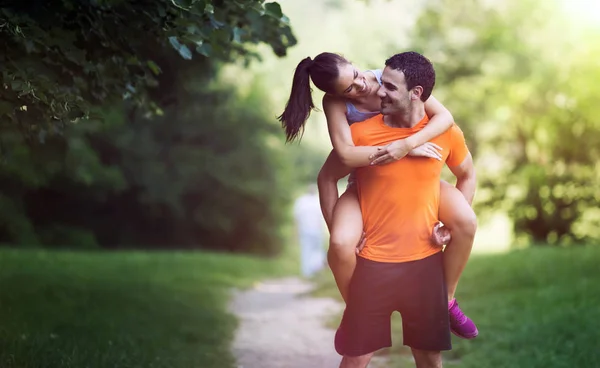 Fidanzata equitazione su uomo in parco — Foto Stock