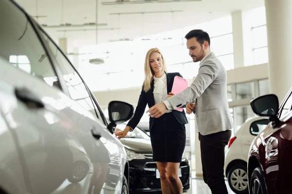 Beautiful blonde woman selling cars — Stock Photo, Image